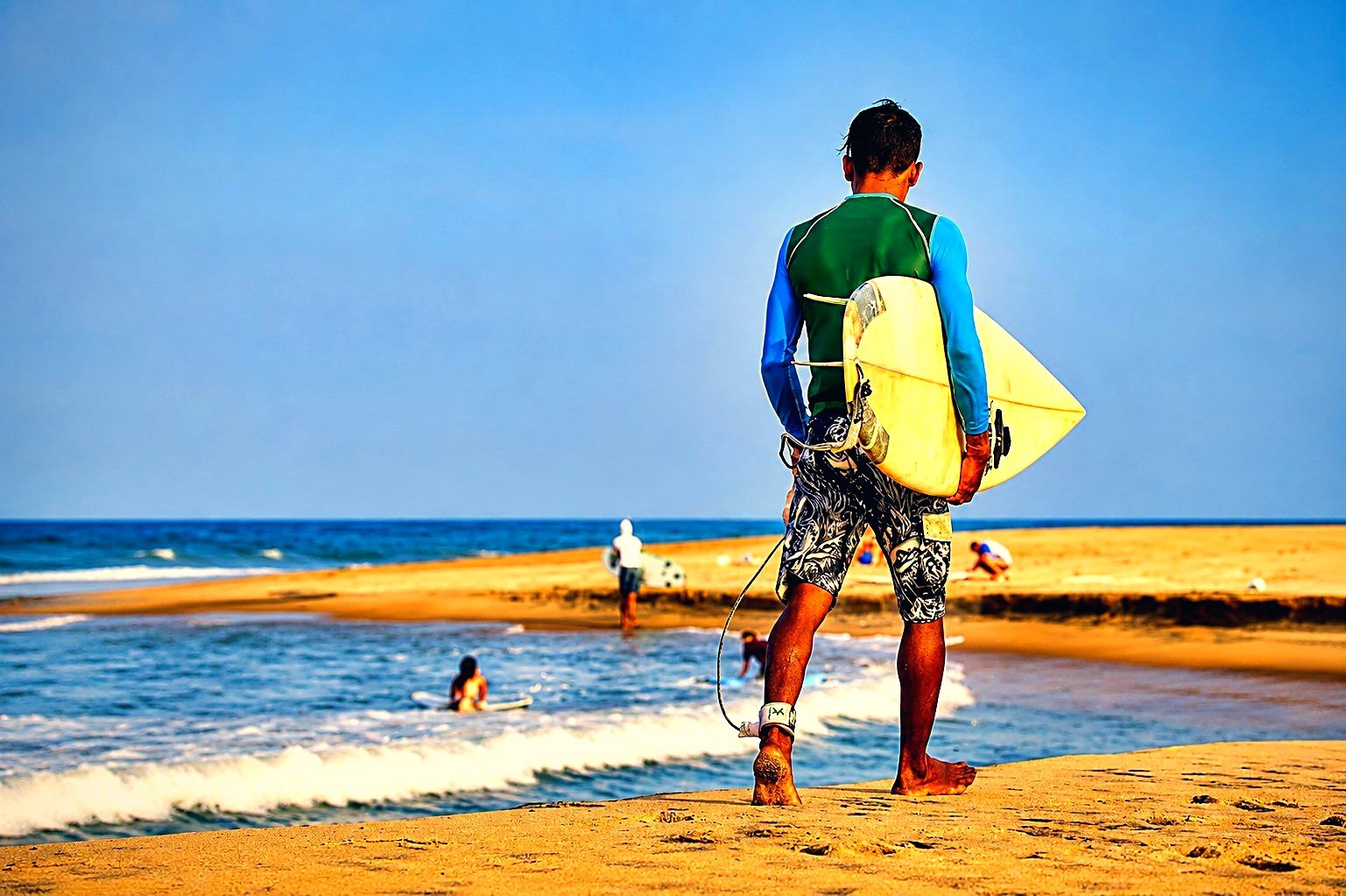 Surfer walking the beach with a board at Arugam Bay